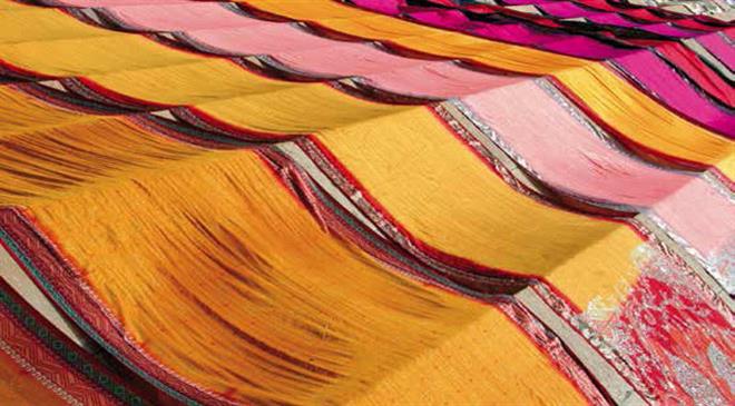 The focus of the new textiles policy for Uttar Pradesh is on apparel manufacturing as it generates employment. How does the policy propose to meet the raw material requirements?