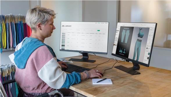 A person sitting at a desk using a computer

Description automatically generated