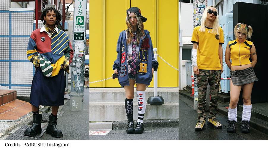 A group of people standing in front of a yellow wall
Description automatically generated