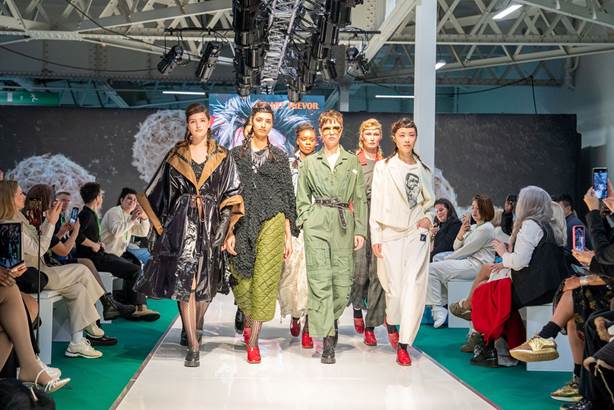 A group of people walking on a runway

AI-generated content may be incorrect.