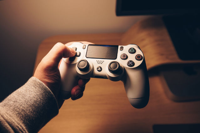 A person holding a game controllerDescription automatically generated with medium confidence