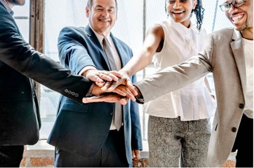 A group of people shaking hands
Description automatically generated
