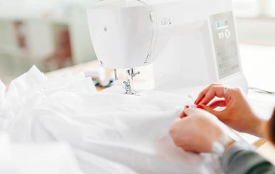 A picture containing appliance, sewing machine, indoor, person
Description automatically generated