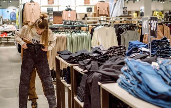 A person looking at clothes in a store
Description automatically generated with medium confidence