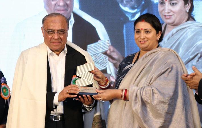 Smriti Irani, minster for textiles and information & broadcasting - presenting SRTEPC lifetime achievement award to Rajen Udeshi, president Polyester Chain, RIL. Courtesy: RIL 