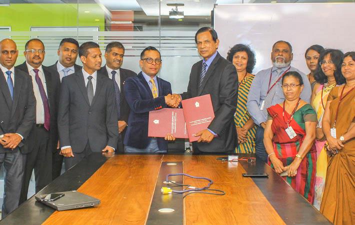 Brandix Chief People Officer Ishan Dantanarayana (centre, on left) and VTA Chairman/CEO Eng. Dr Lionel Pinto exchange the agreements in the presence of representatives of the two organisations.